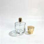 Короткий цилиндрический флакон для духов 50ml, представленный с декоративным колпачком рядом с флаконом, демонстрирует конфигурацию упаковки аромата со снятым колпачком.