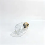 Side-lying 50ml short round perfume bottle showing its circular base and smooth cylindrical body from a bottom-facing angle.