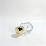Side-lying view of the 50ml perfume bottle highlighting its compact cylindrical profile and decorative cap from a horizontal angle.