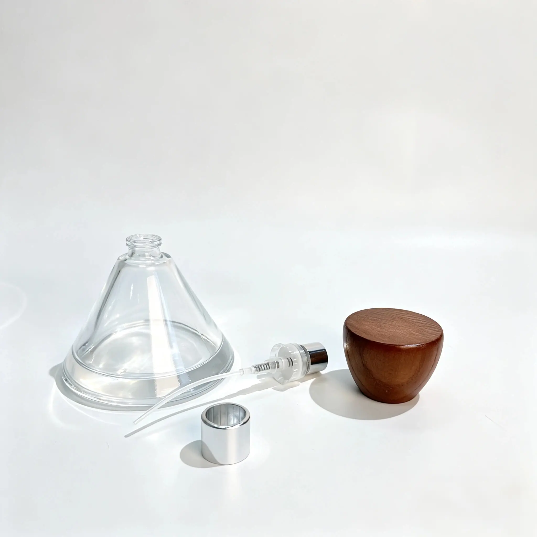 50ml wide round perfume bottle displayed with its separate fragrance sprayer, dip tube, and conical wooden cap components.