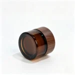Side detail of the wood-grain screw cap supplied with the 5g amber glass cream jar, showing the cap's exterior appearance.