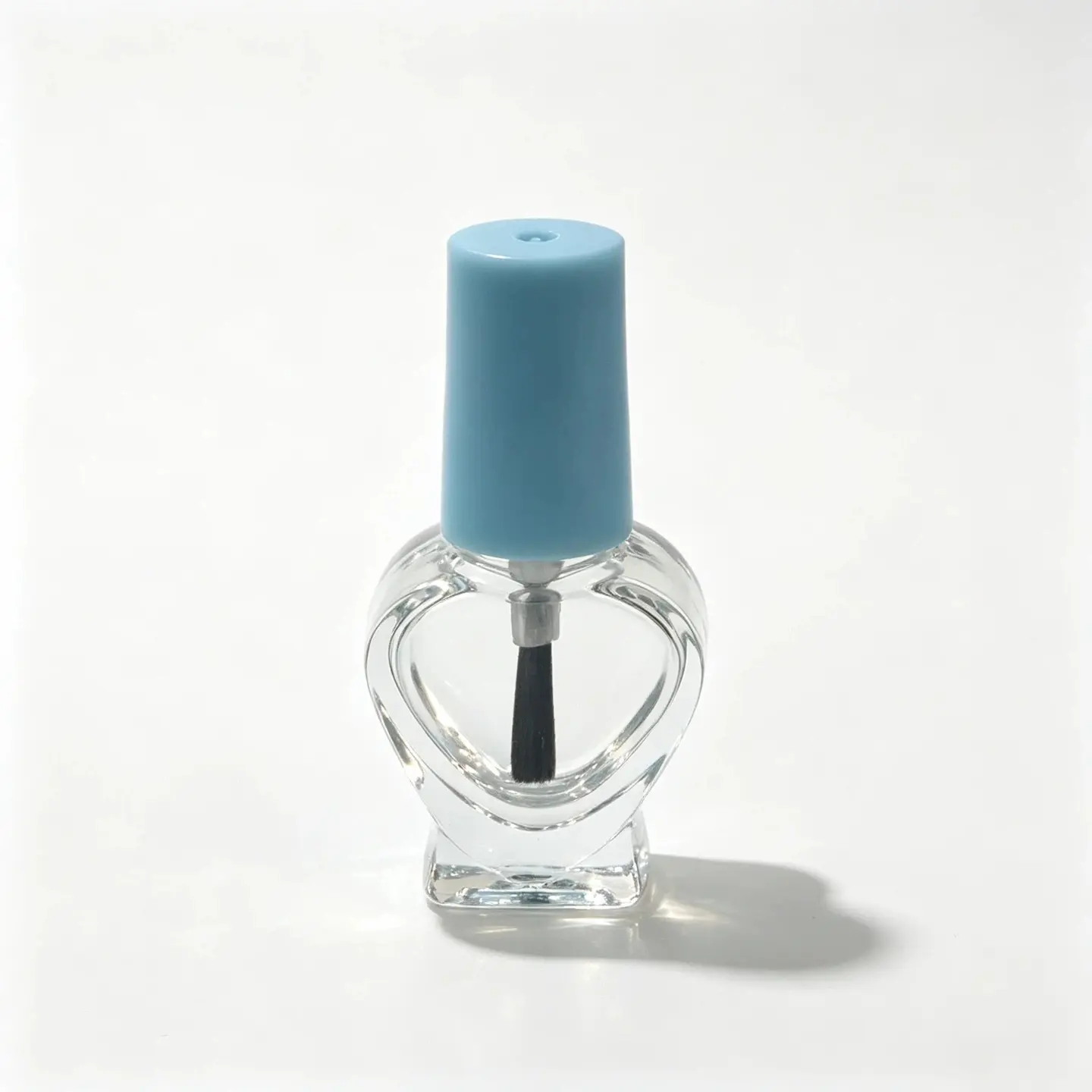5ml frasco de vidrio en forma de corazón para esmalte de uñas mostrado desde el frente con su tapa y conjunto de pincel
