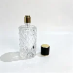 An 80ml diamond-faceted perfume bottle with its decorative cap removed and positioned beside the bottle, showing the uncapped fragrance packaging configuration.
