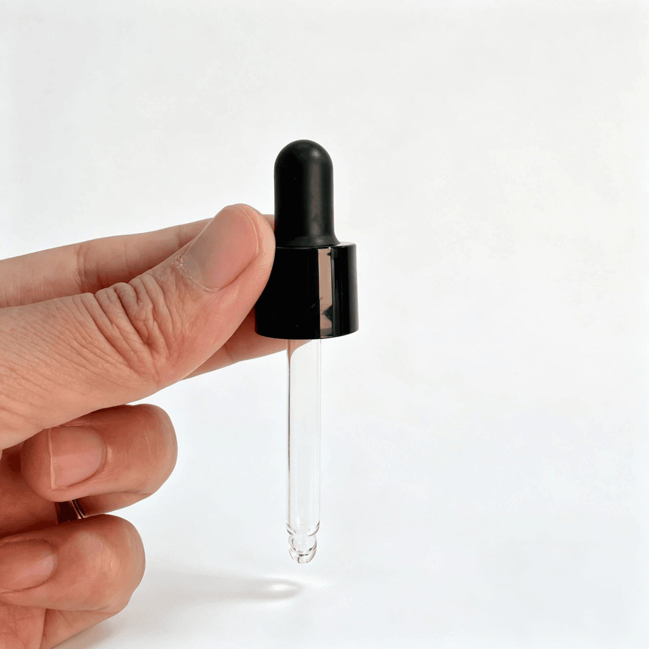 Mini pipette dropper with matte black rubber bulb, glossy black aluminum collar, and transparent glass pipette shown from the front