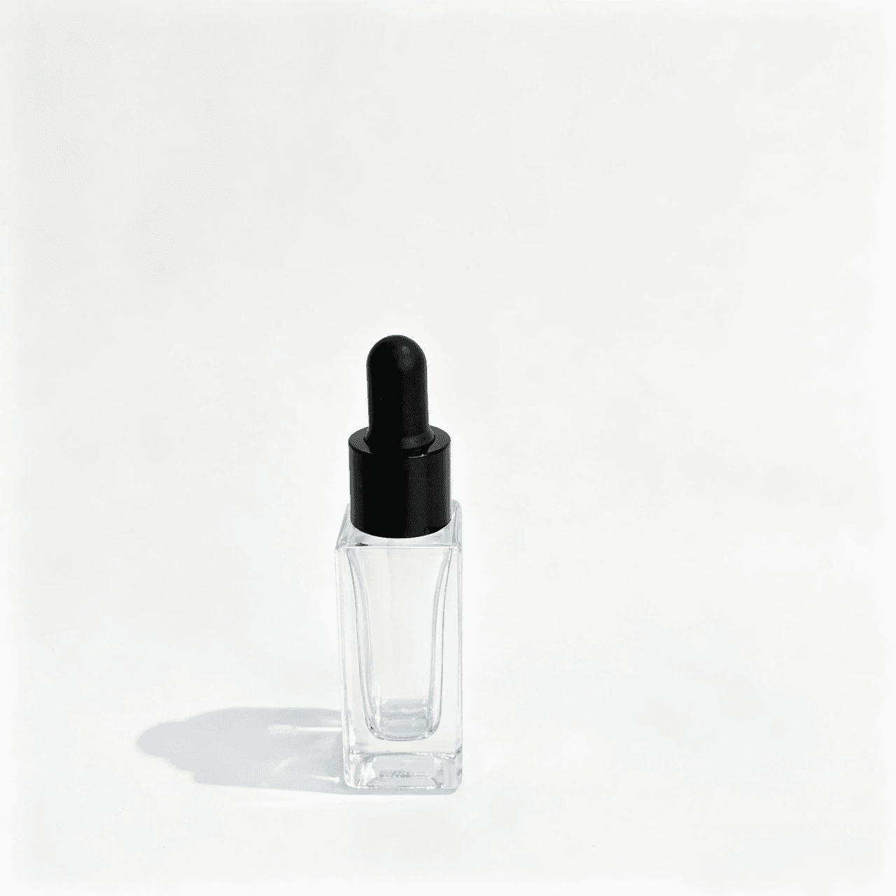 Mini pipette dropper assembled with a cosmetic bottle showing the matte black rubber bulb and glossy black aluminum collar