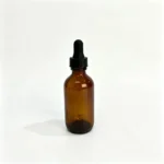 Black screw cap glass dropper assembled with a cosmetic bottle showing the rubber bulb and closure configuration