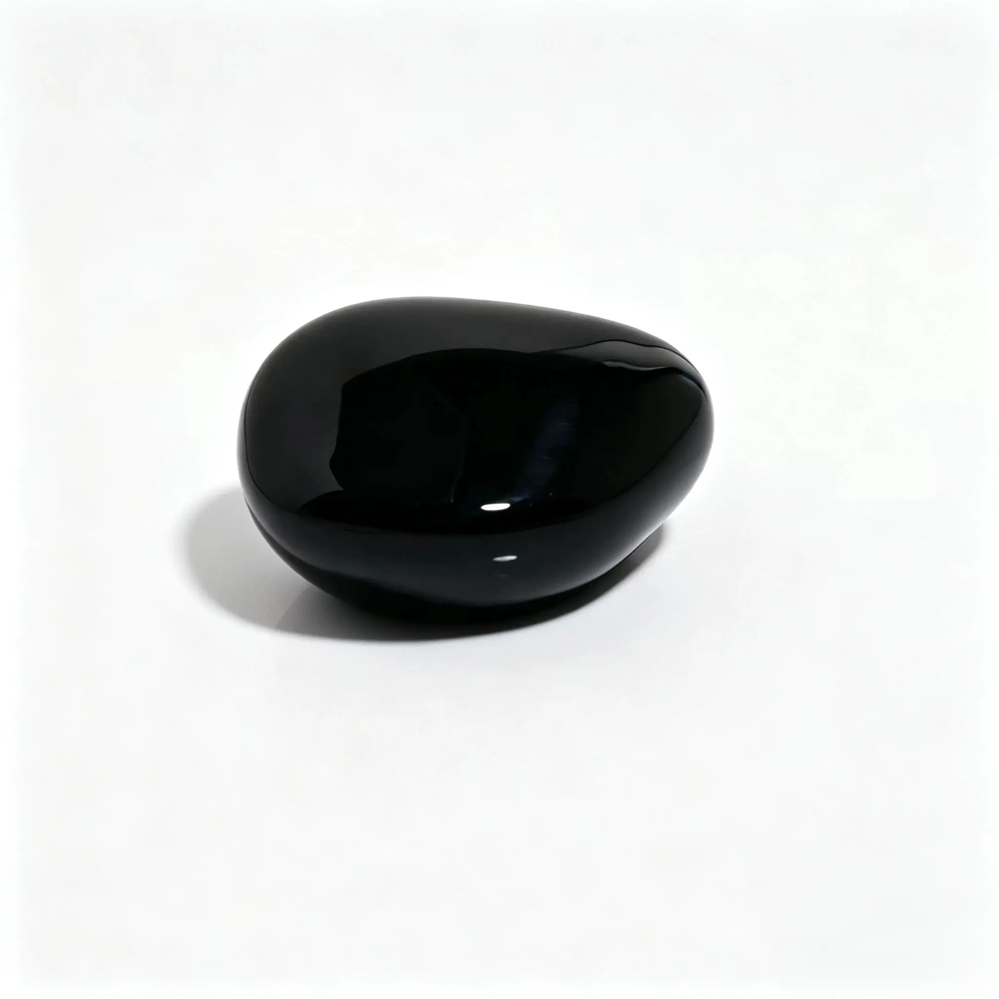 Vedere din spate a capacului de parfum din rășină negru lucios în formă de pietricică Capac de parfum din rășină solidă negru lucios, prezentat din spate, cu forma sa asimetrică inspirată de pietricică și suprafața netedă vizibilă